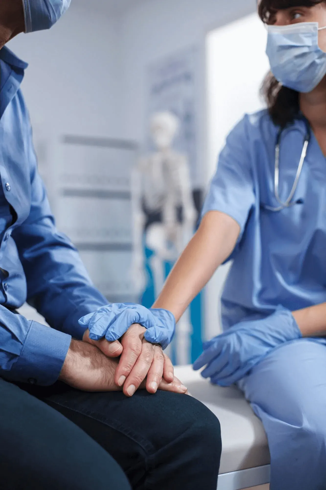 Clinician holding a patient's hand during a consultation